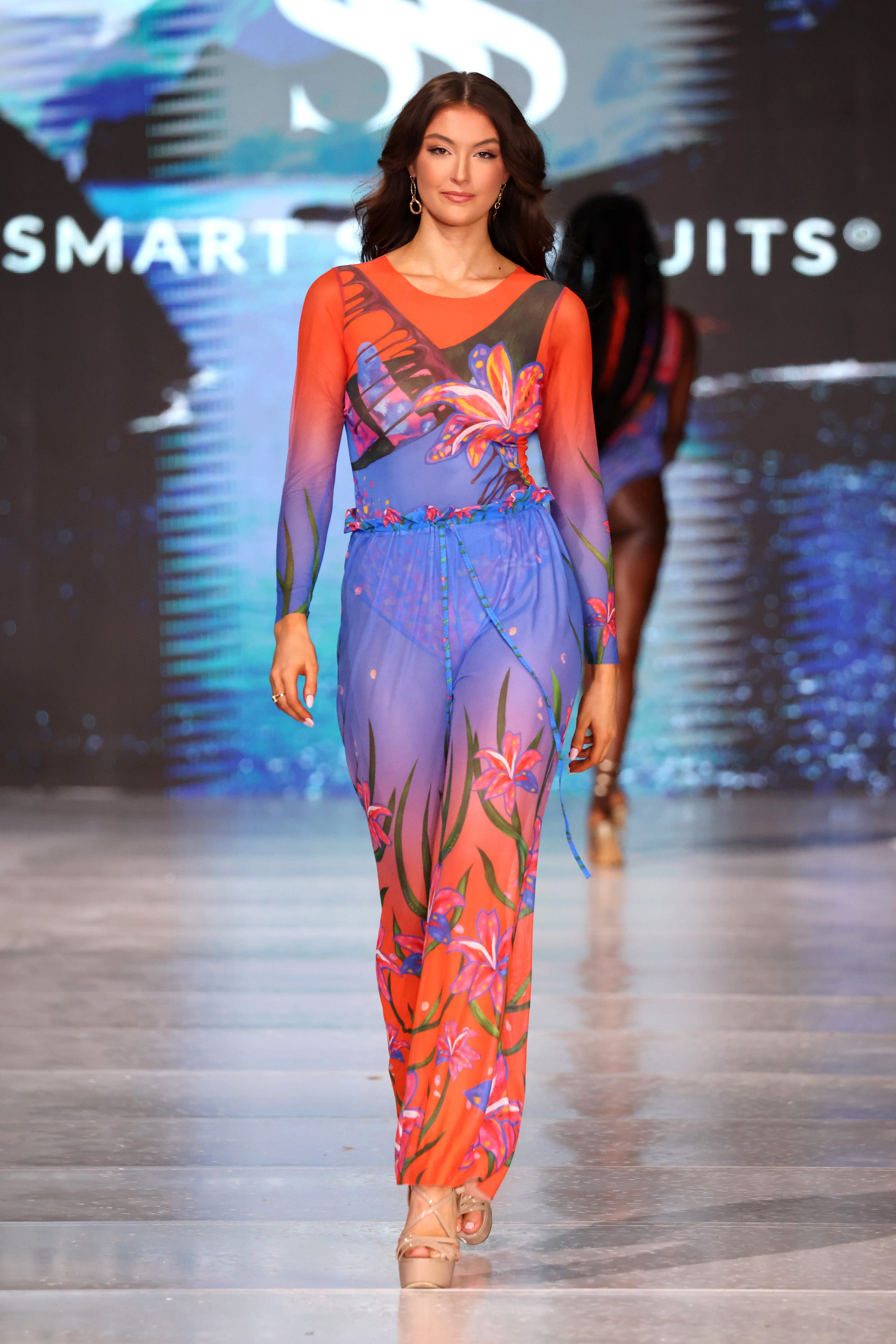 This text promotes sustainable tan-through smart swimsuits featuring the elegant Lily print. It highlights a one-piece swimsuit with sleeves, emphasizing sophistication and timeless elegance. Users are encouraged to shop now to elevate their feminine style.